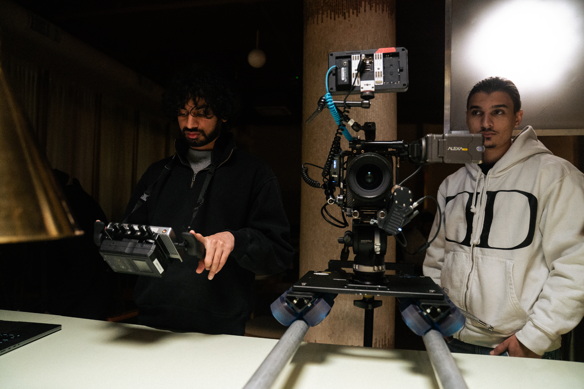 Focus puller and operator on an ARRI Alexa rig mounted to a camera dolly on set